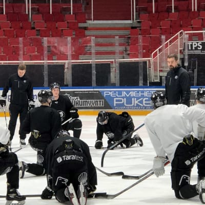 Turun Palloseuran jääkiekkojoukkueen pelaajia kuuntelee, kun päävalmentaja Jussi Ahokas puhuu.