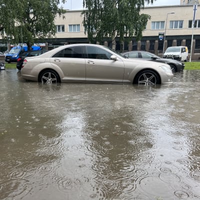 Autoja melko korkean veden varassa ja sataa lisää.