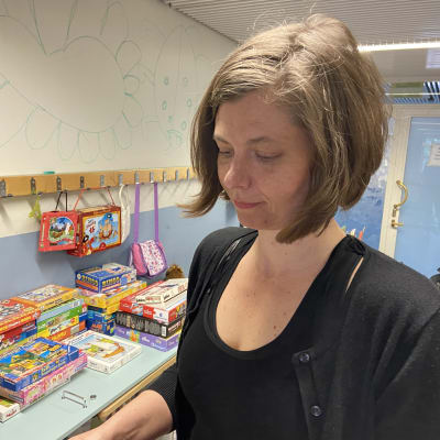 Nainen katselee lasten kuvakirjaa.