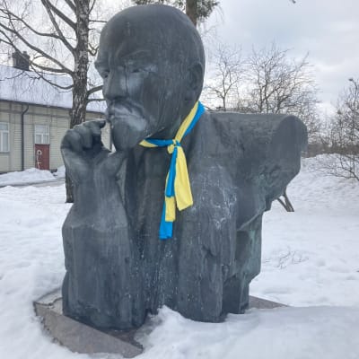 Leninin patsas talvisessa maisemassa kotkalaisessa puistossa. Patsan kaulaan oli maaliskuun 2022 alussa kiedottu Ukrainan sini-keltaisissa väreissä oleva huivi.