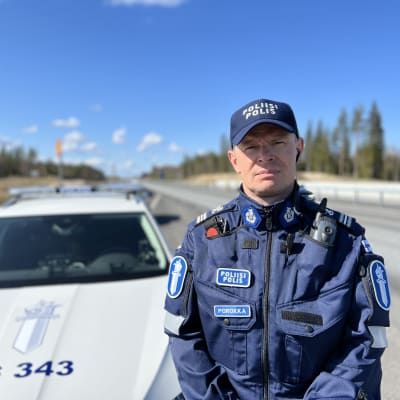 Komisario Seppo Porokka 5-tien laidassa poliisiauton edessä.