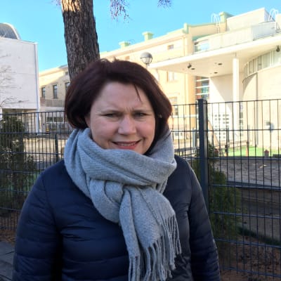 Kuvassa johtava diakoniatyöntekijä Camilla Honkala seisoo seurakuntakeskuksen pihalla.