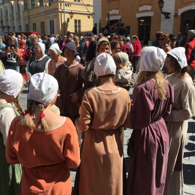 Folk står i en samling under medeltida marknaden i Åbo. 