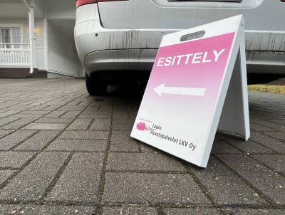 Asuntoesittelykyltti omakotitalon pihalla.