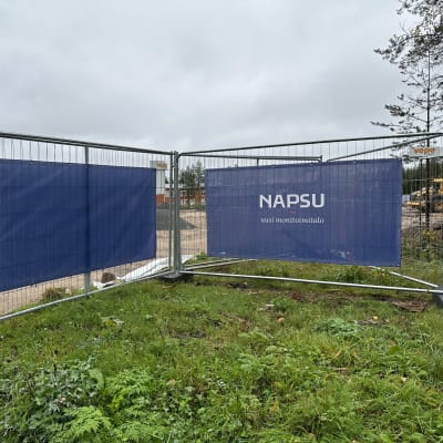 Napapiirin monitoimitalon rakennustyömaata kiertävä aita, jossa lukee Napsu - uusi monitoimitalo.