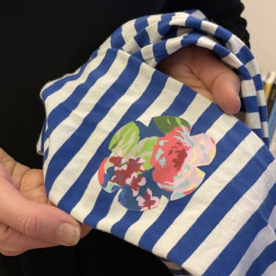 Vaatelaastari-paikka kiinnitettynä paidan hihaan.