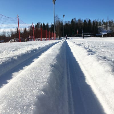 Koneella ajettu latu-ura Helsingin Paloheinässä. Talvi, pakkaspäivä ja aurinko paistaa.
