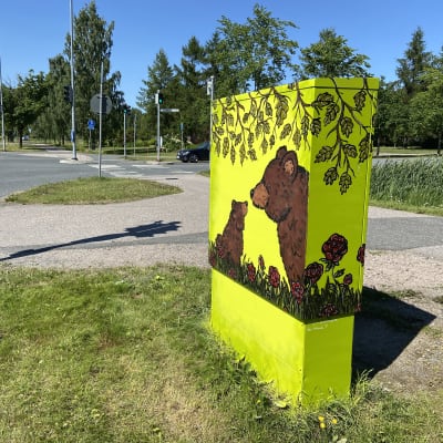 Karhu ja karhunpentu maalattuna keltaisella pohjalla jakokaappiin Riihimäellä Kirjauksentien varrella.