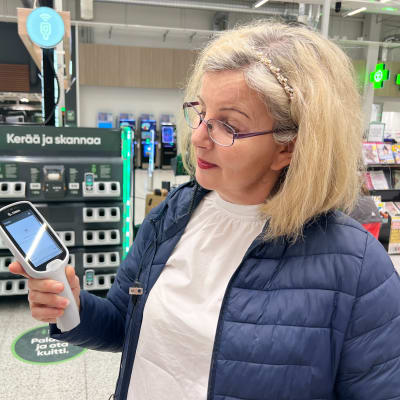 Ylen toimittaja Minna Rosvall katsoo skannaus-laitetta Turussa Tampereentien Prismassa. 