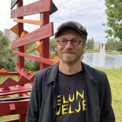 Kuvataiteilija Tuomas Korkalo seisoo ympäristötaideteoksen vieressä. Taustalla on Rovaniemen Kirkkolampi.