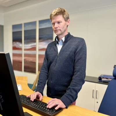 Etelä-Karjalan Yrittäjien toimitusjohtaja Marko Hanhisuanto seisoo työpödän takana kädet näppäimistöllä.