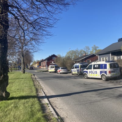 Poliisiautoja kadun vieressä.