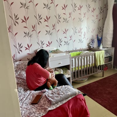 En ukrainsk flyktingkvinna ammar sitt barn i en lägenhet.