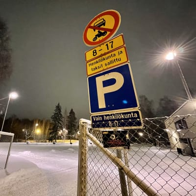 Liikennemerkkejä Hämeenlinnan Seminaarin koulun pihassa talvella hämärässä. 