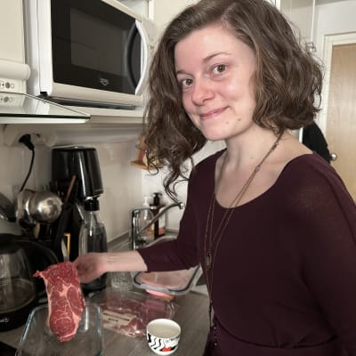 Kuvassa Maaret Lyytinen esittelee raakaa pihviä, jonka hän aikoo valmistaa itselleen lounaaksi.