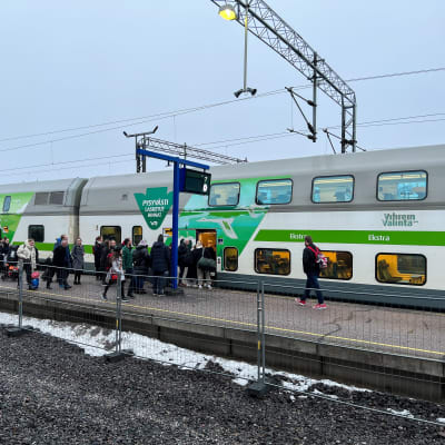 Ihmisiä Turun rautatieasemalla junan vieressä. Matkustajat jonottavat Tampereelle lähtevään junaan. 