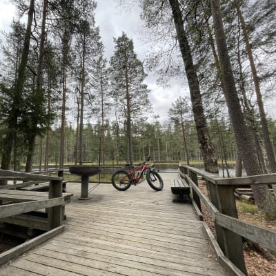 Sähköavusteinen maastopyörä luontopolun taukopaikalla.