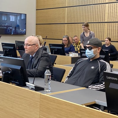 Syytetty, asianajajia ja yleisöä Päijät-Hämeen käräjäoikeuden istuntosalissa.