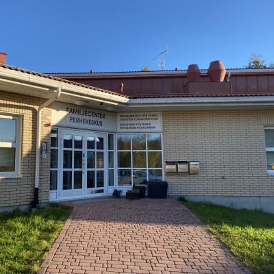En dörr i ett tegelhus med en skylt där det står familjecenter.