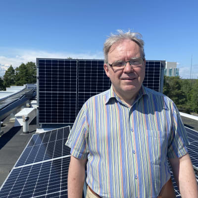 Ulf Sjögren på tak med solpaneler i bakgrunden
