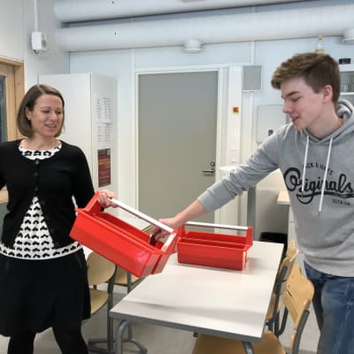 Studiehandledare Lotta Sundgren och Hamish Simpson som lägger sin mobiltelefon i en av Pargas Svenska Gymnasiums nya telefonlådor.