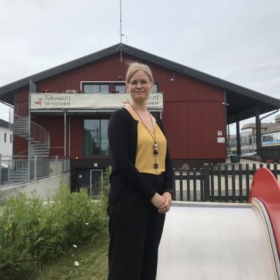 Kvinna poserar framför byggnad