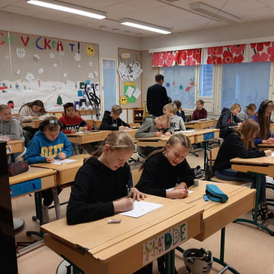 Ett klassrum med sjätteklassister som sitter och ritar.
