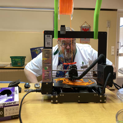 Mies tulostaa 3D-tulostimella