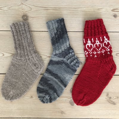 Kolme erilaisia sukkia lattialla