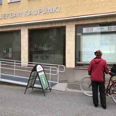 Kaksi naista polkupyörineen Lieksan keskustan raitilla.