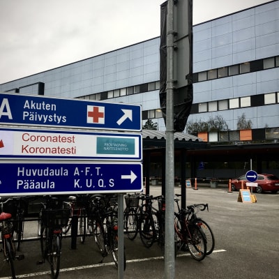 Cyklar i en cykelställning utanför ett sjukhus.