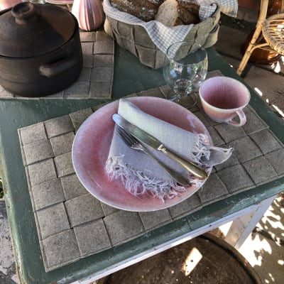Ett bord är dukat med bordstabletter, grytunderlägg och brödkorg gjorda av linfilt