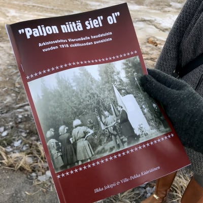 Suomen sisällissodasta Vierumäen taisteluista kertova kirja miehen kädessä