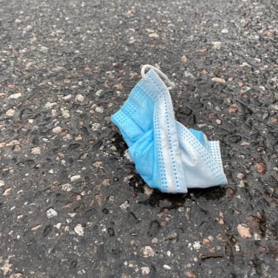 Kadulle heitetty kasvomaski Helsingissä.
