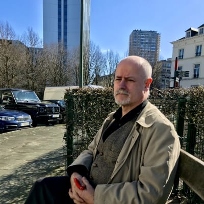 Intervjuobjektet Philippe Vandenberghe sitter på en bänk i Bryssel. 