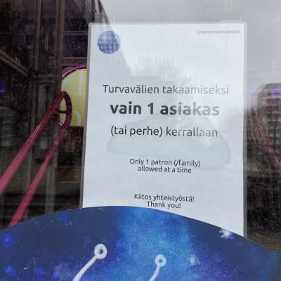 Kirjastoauton ovessa korona-ajan rajoitushuomautus, vain yksi asiakas kerrallaan