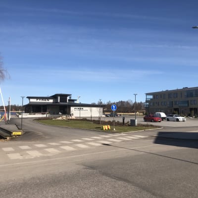 En parkeringsplats framför en restaurang och ett bostadshus i Norra hamnen i Ekenäs.