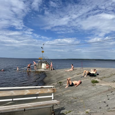 Tampereen Rauhaniemen rannan kalliot etualalla, taustalla uimarappuset 
