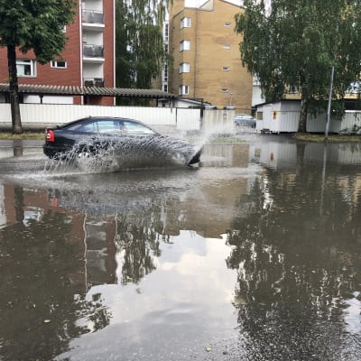 Auto ajaa lainehtivalla Kuopion Satamakadulla rankkasateen jälkeen.