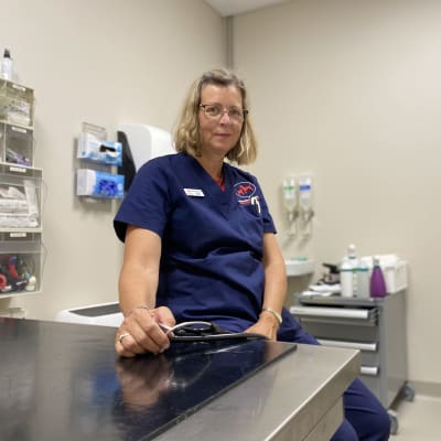En kvinnlig veterinär sitter i sitt mottagningsrum på veterinärkliniken.