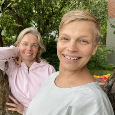 Tehdas tanssii- festivaalin taiteelliset johtajat Tanja Kunnari ja Tuula Penttilä poseeraavat vanhan omenapuun kyljessä puutarhassa.