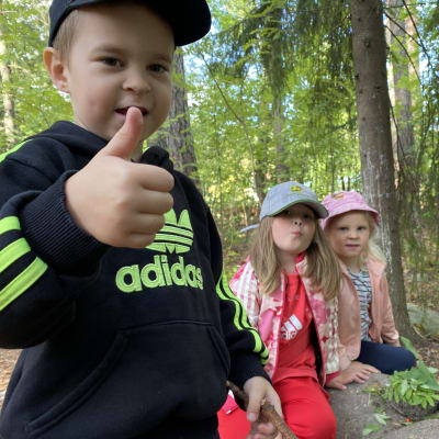 Hämeenlinnalaisen Kankaantaan päiväkodin esikoululaiset Sebastian Smirnov, Milja Marttila ja Milla Tiukka leikkivät metsässä.