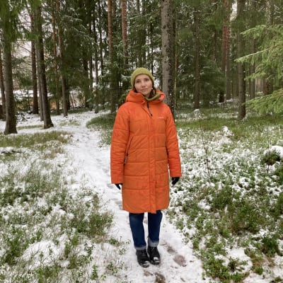 Jenni Räinä seisoo metsässä