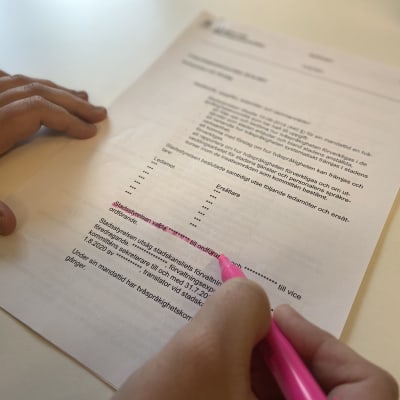 En rapport, där flera namn strukits. Händerna på en person syns, hen sträckar över delar av texten med en markeringstusch.