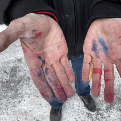 Graffititaiteilija Don Poron kädet spraymaalitahroilla.