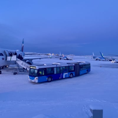 Rovaniemen lentokenttä, ulkomaisia lentokoneita ja edustalla bussi. 