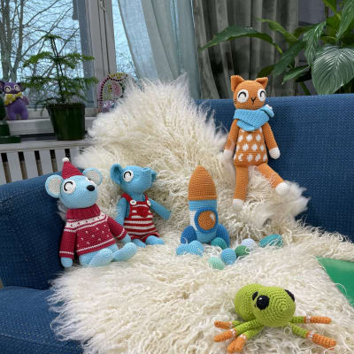Virkade gosedjur och leksaker på en soffa.