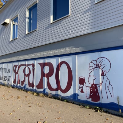 Kadunvarrella sijaitsevan rakennuksen kivijalkaan tehty kyltti, jossa lukee ravintola Kairo