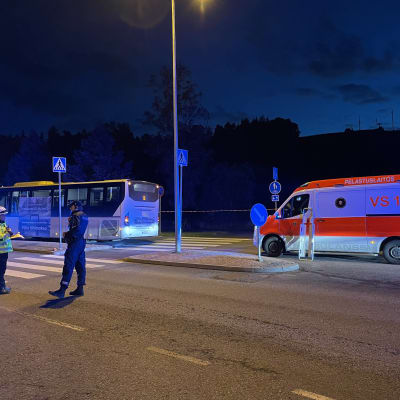 En buss och ambulans och räddningsverkets samt poliser står framför dem vid en korsning i Hirvensalo. 