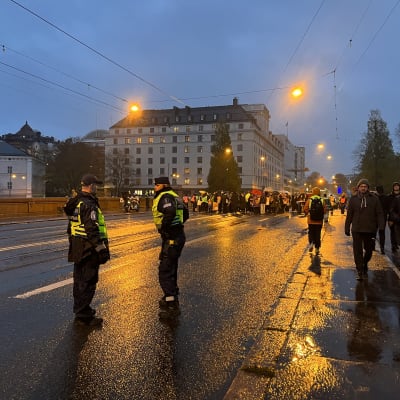 Mielenosoittajia ja kaksi poliisia Pitkälläsillalla.